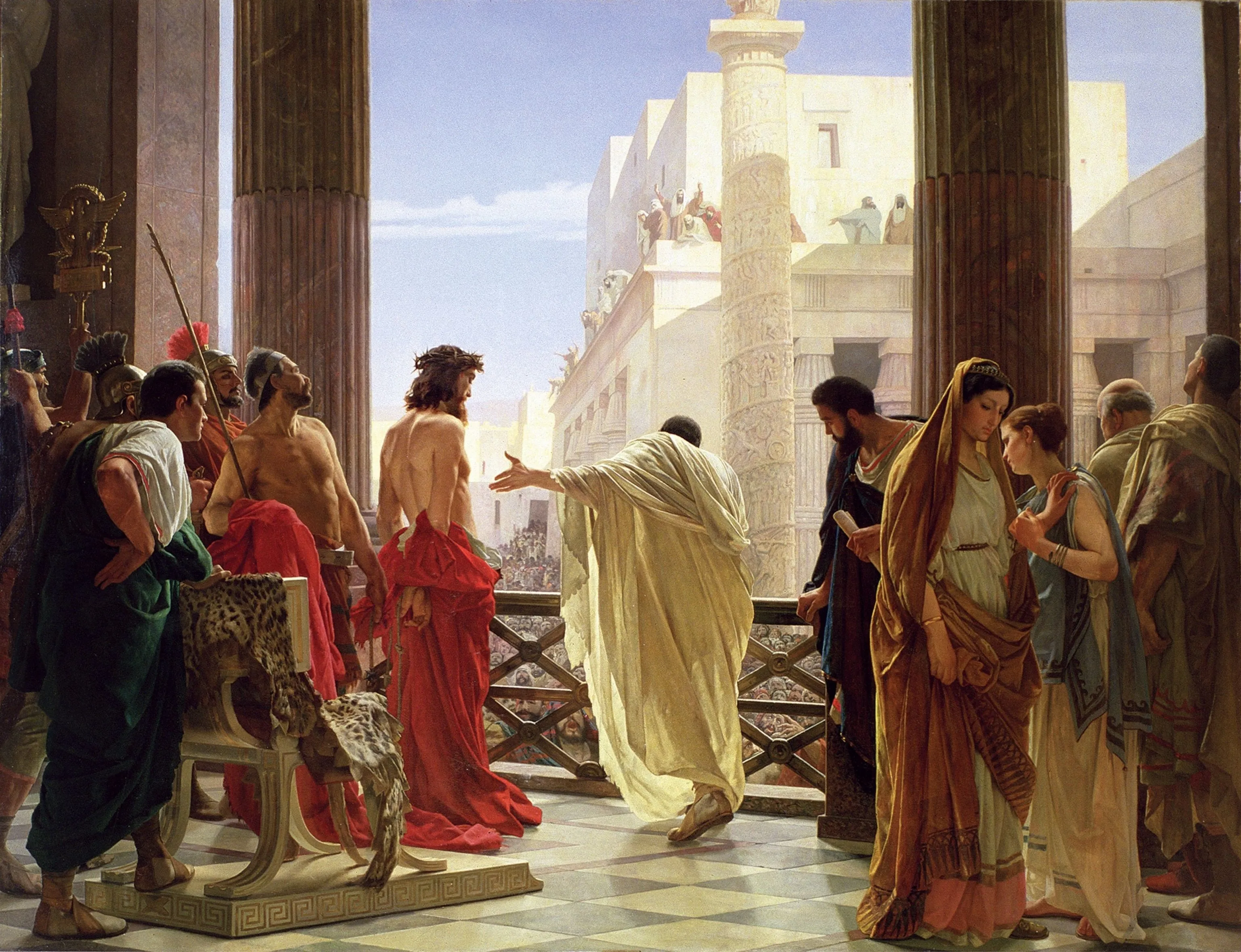 Oil painting of a sunlit balcony between tall marble columns. Pilate, in a pale cream robe with his back to us, stretches one arm toward Jesus, who stands beside him wearing a crown of thorns, bare to the waist, his hands bound behind him and a red robe around his hips. Below the railing a dense crowd fills the street, and more people gesture from a rooftop across the way. Roman soldiers, a gilded eagle standard and an empty chair draped in a leopard skin are on the left; on the right, a woman in a gold mantle looks down while another woman leans toward her.